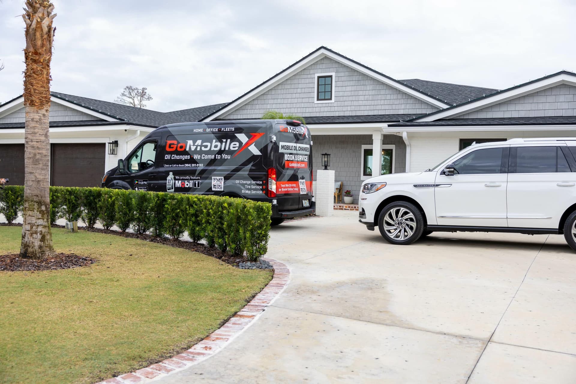 A certified technician performing a mobile oil change on an SUV