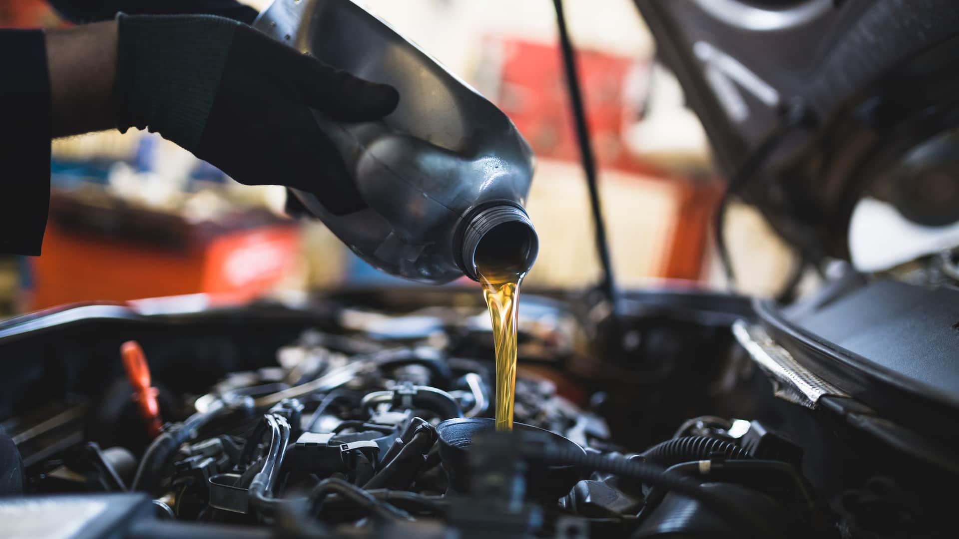 Premium synthetic oil being poured into an engine