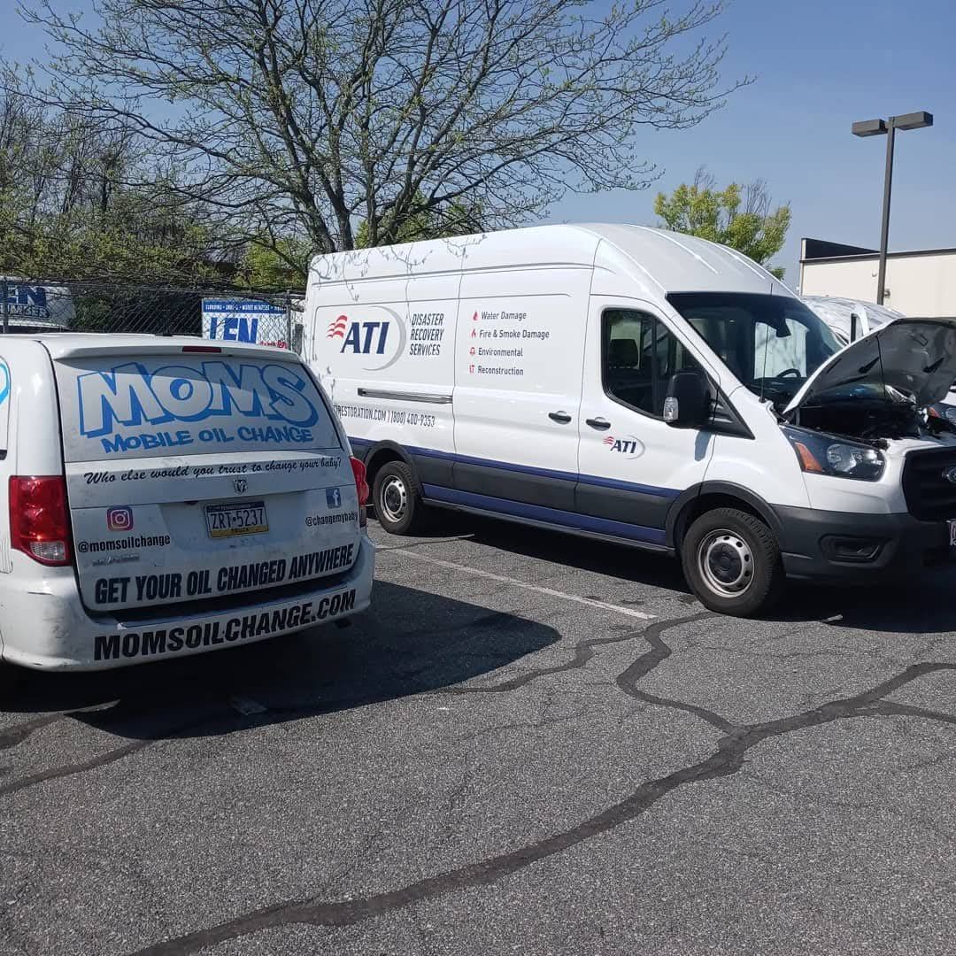 Fleet service beside an ATI Disaster Recovery van with its hood up.