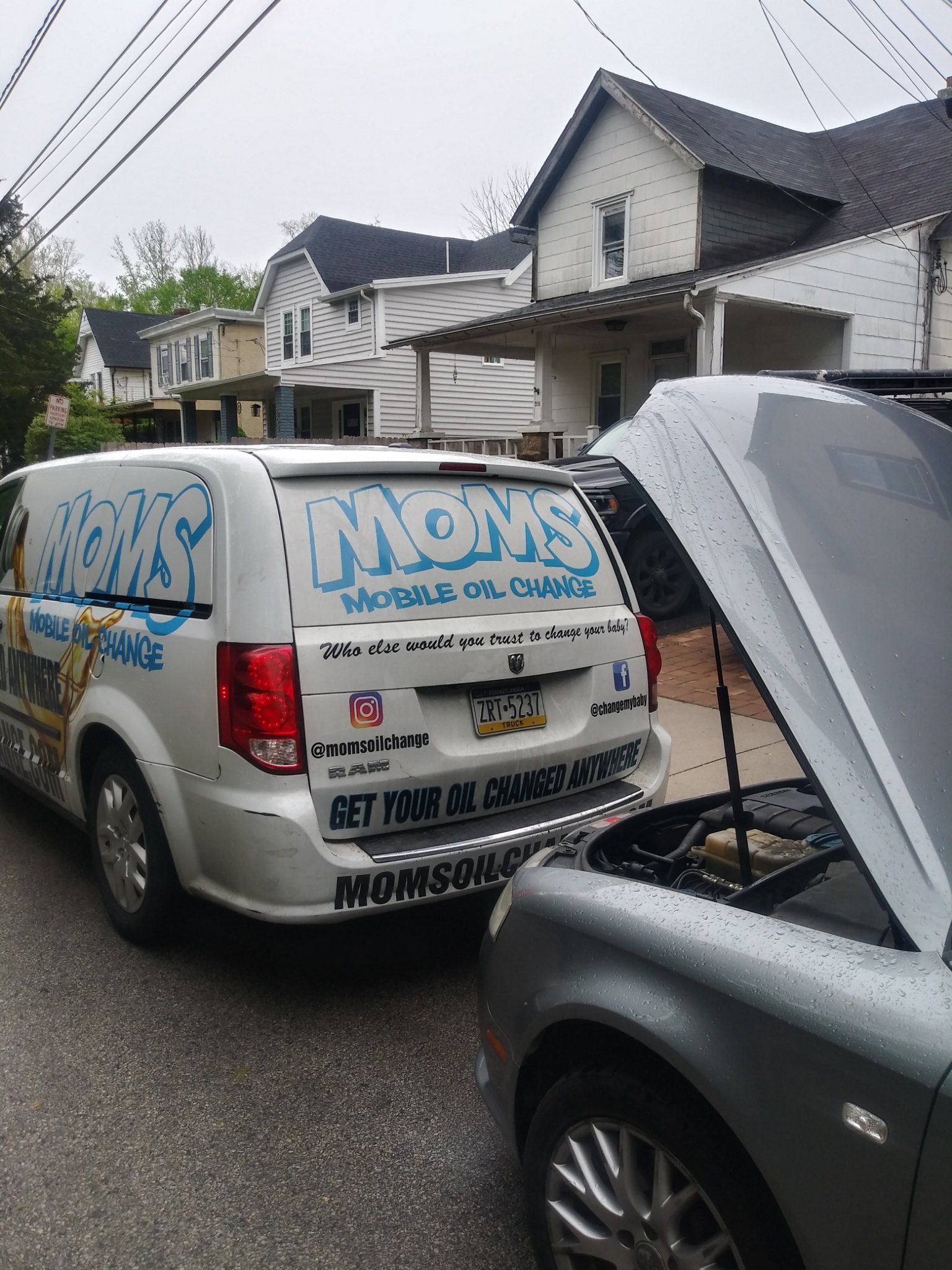 Rear view of the MOMS van during a driveway oil change.